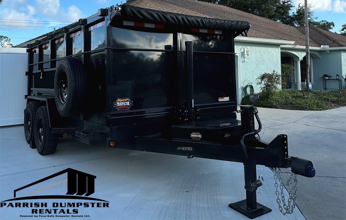 Pave-Safe Dumpster Rentals LLC Dump trailer parked in driveway at job site with Pave-Safe Dumpster Rentals LLC logo.